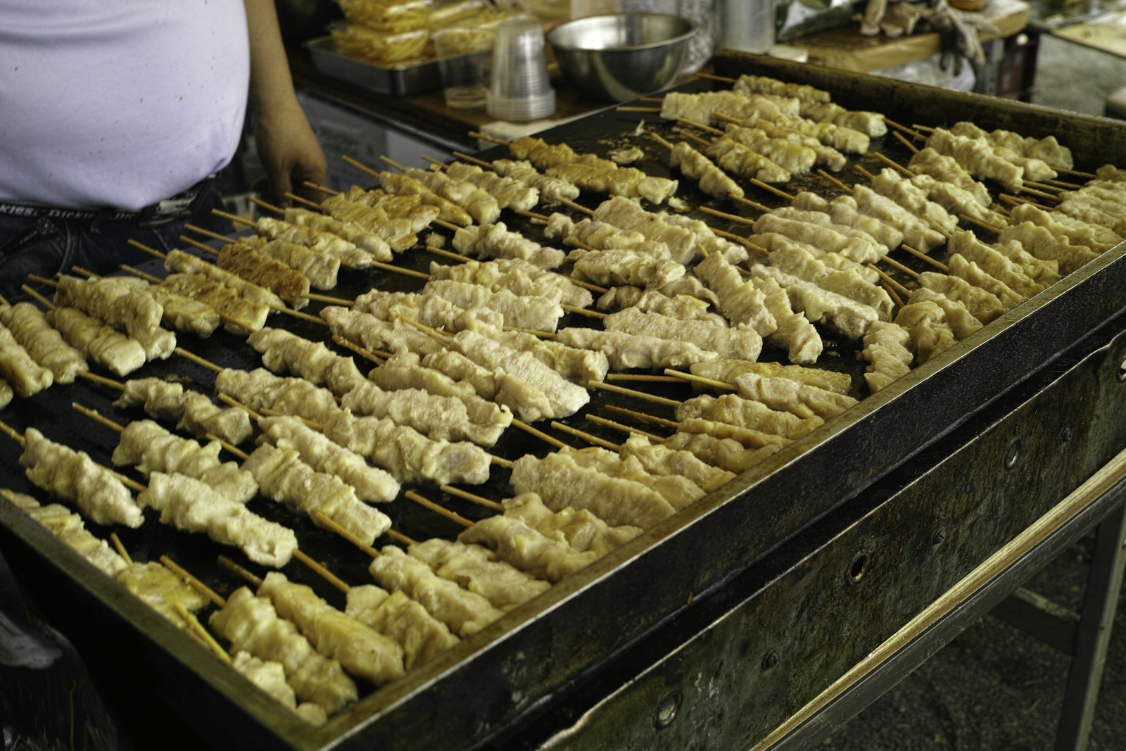炭火で串を焼き上げる料理人